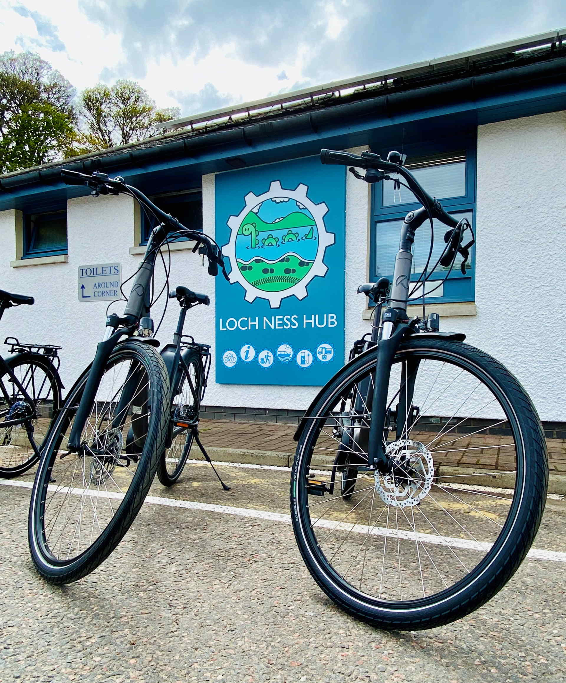 Group of people and bikes in front of the cycling hub building
