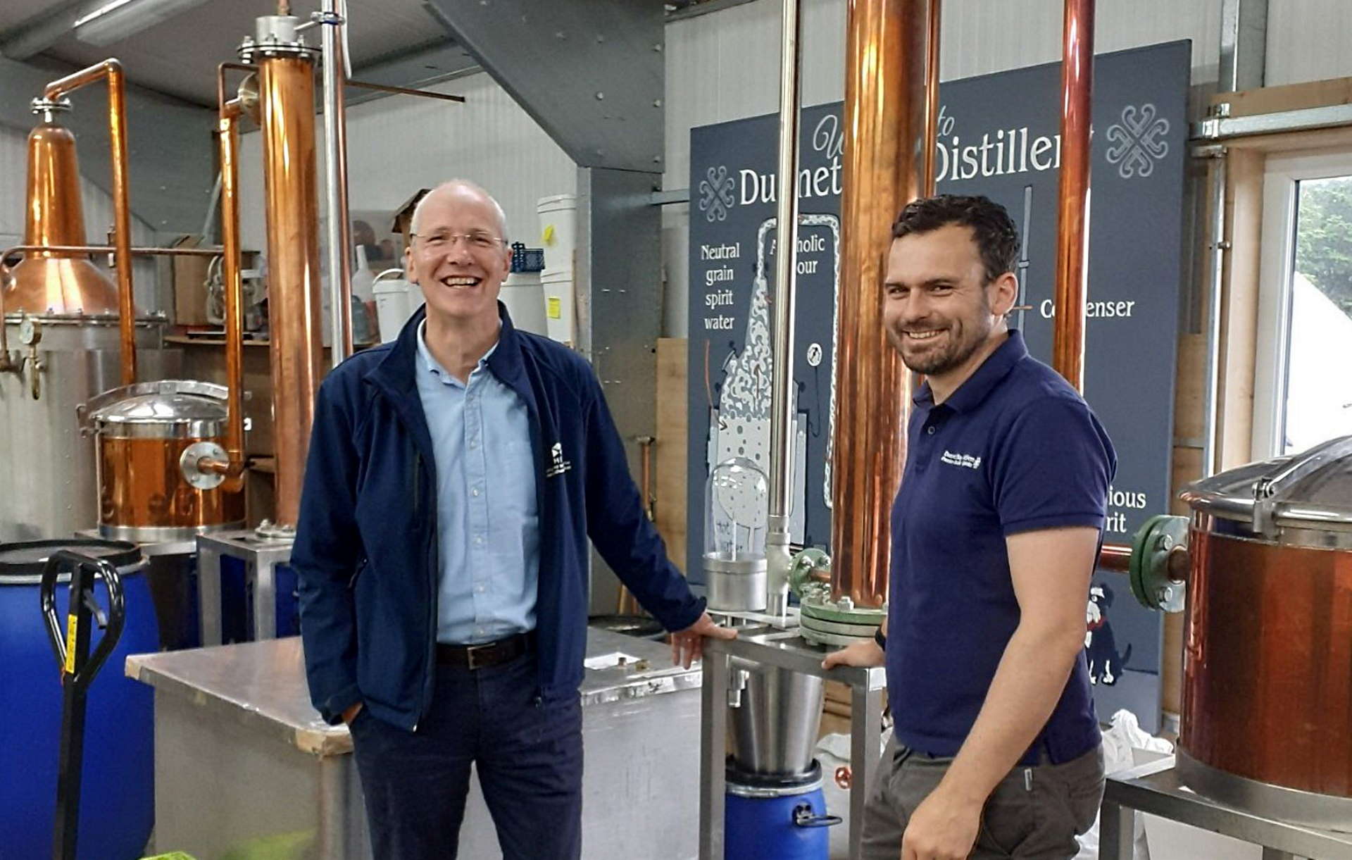 HIE CEO Stuart Black in front of a still at Dunnet Bay Distillery