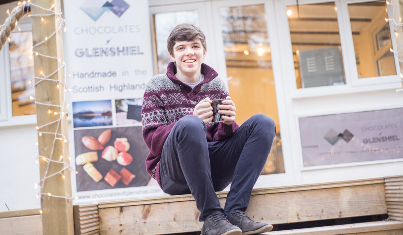 Young Highland chocolatier, Finlay Mackenzie, sitting outside his Wester Ross shop