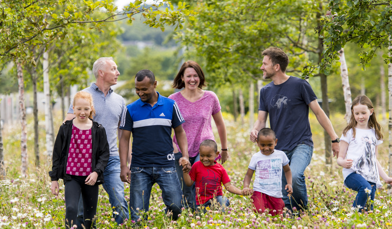 People walking through a field with wild flowers