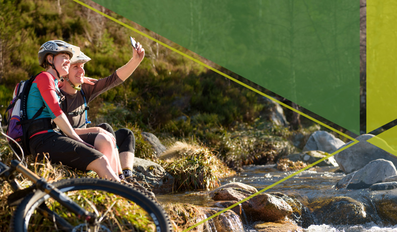 Bikers stop to take a selfie next to river in the Cairngorms National park