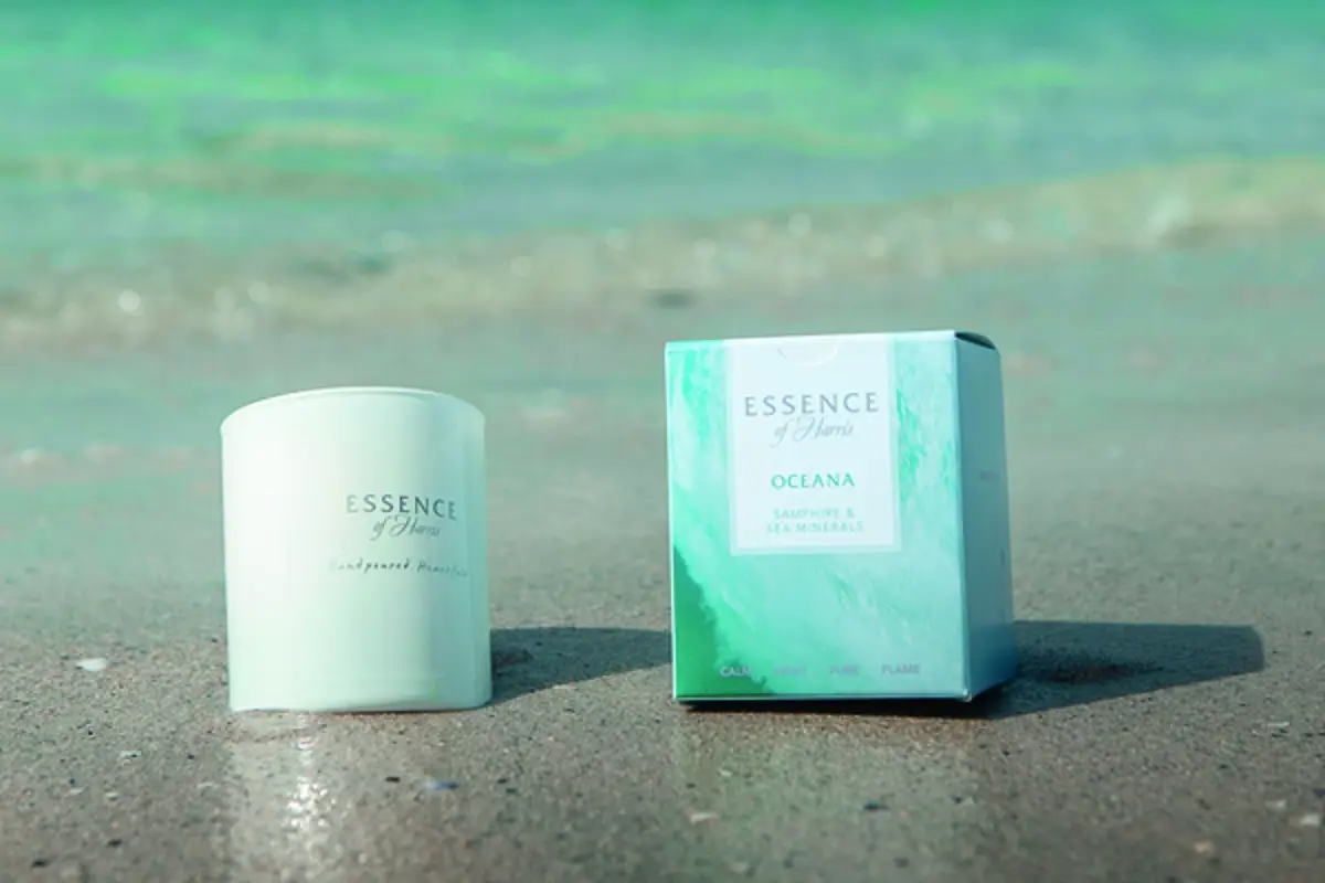 Essence of Harris scented products sitting on white sand beach