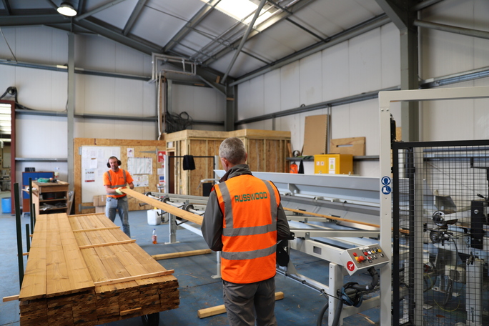 Two workers lifting wood inside Russwood factory, Newtonmore