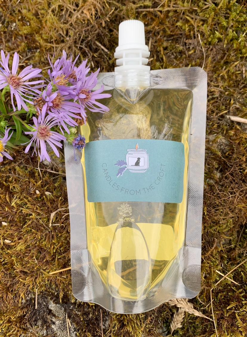 Clear plastic pouch with yellow hand lotion with a purple flower beside it