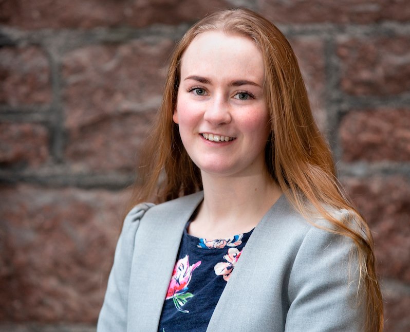 Ciara Bow from Gledfield Distillery wearing a flowery blue dress and smiling