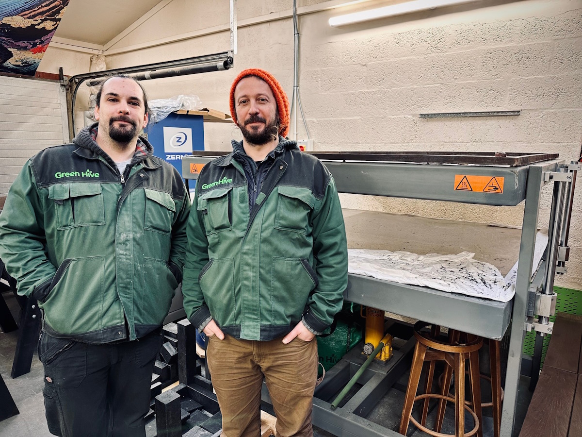 Green Hive staff in front of ne machine