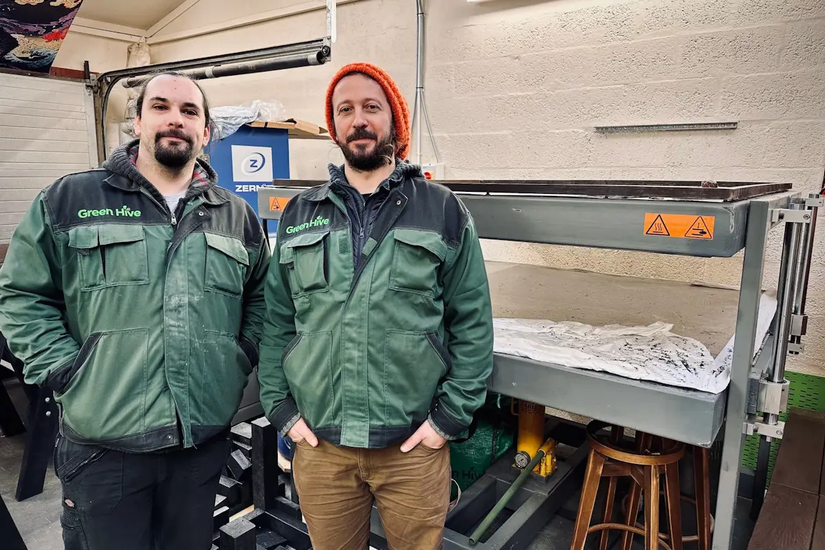 Green Hive staff in front of ne machine